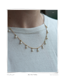 Pearl Mini Necklace, close-up worn on a model's neck over a white top, a solid 18k gold chain necklace with small dangling freshwater pearls. Tarnish-resistant and made for everyday wear — Maya & Mason handcrafted fine jewellery.