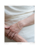 Aspen Bracelet, close-up worn on a model's wrist resting on white fabric, a solid 18k gold pebble-link chain bracelet. Tarnish-resistant and made for everyday wear — Maya & Mason handcrafted fine jewellery.