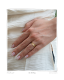 Two Rail Band worn on a model's hand resting on white fabric, a solid 18k gold ring featuring two parallel stacked rails. Tarnish-resistant and made for everyday wear — Maya & Mason handcrafted fine jewellery.