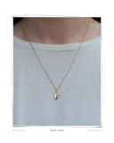 Martine Pendant, a solid 18k gold necklace with a small leaf-shaped pendant, worn on a model's neck. Tarnish-resistant and made for everyday wear — Maya & Mason handcrafted fine jewellery.