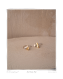 Martine Mixed Studs, pair displayed on a beige textured fabric background, solid 18k white and yellow gold mixed-metal stud earrings. Tarnish-resistant and made for everyday wear — Maya & Mason handcrafted fine jewellery.