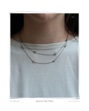 Aquamarine White Gold necklace, a close-up of a model wearing a layered solid 18k white gold necklace set with aquamarine stones. Tarnish-resistant and made for everyday wear — Maya & Mason handcrafted fine jewellery.