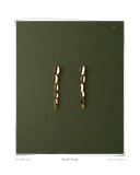 Cascade Earrings, pair laid flat on a dark green background, solid 18k yellow gold dangle earrings made from cascading curl links. Tarnish-resistant and made for everyday wear — Maya & Mason handcrafted fine jewellery.